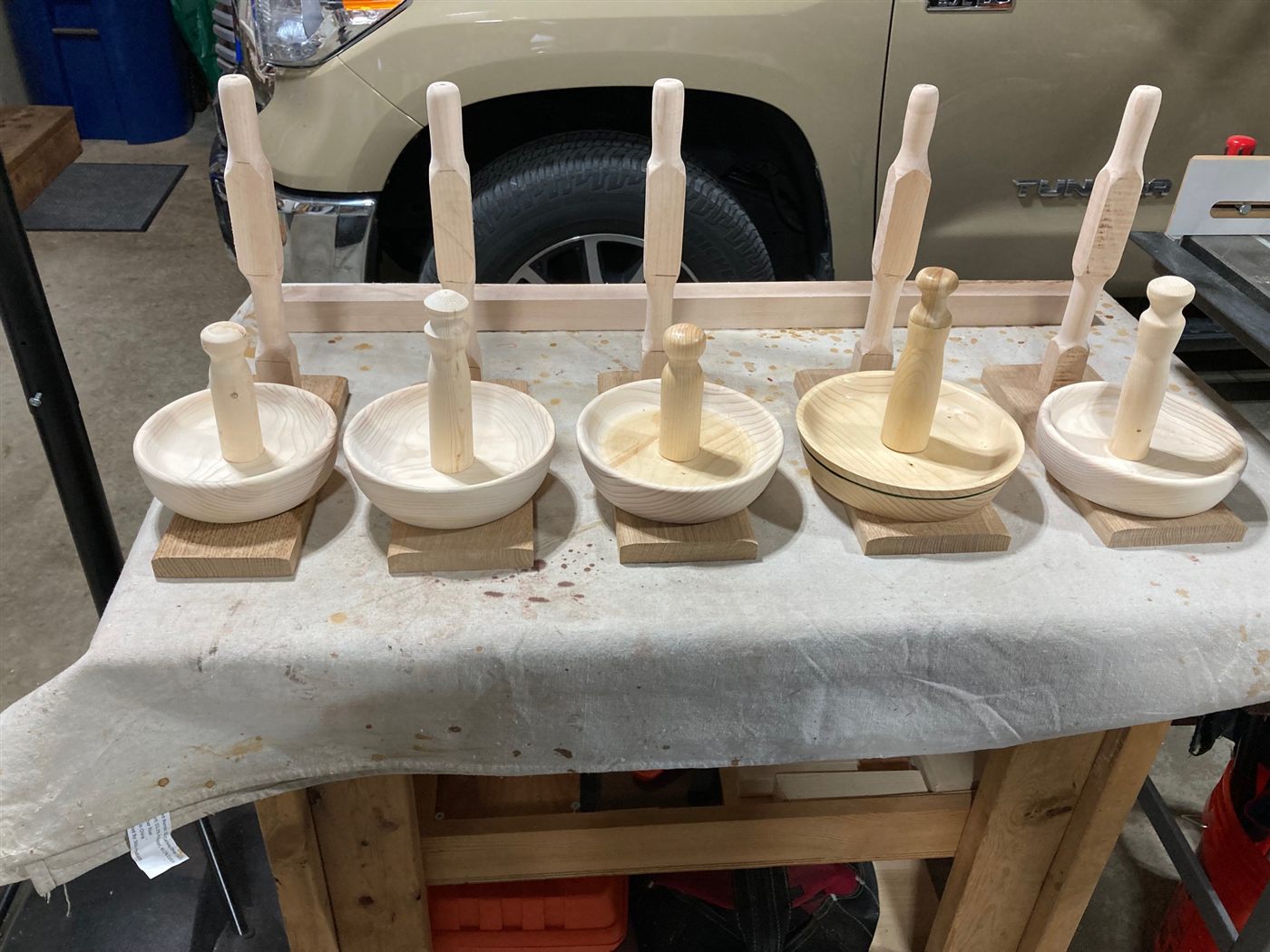 Five freshly turned binding bowls with stands on a workbench