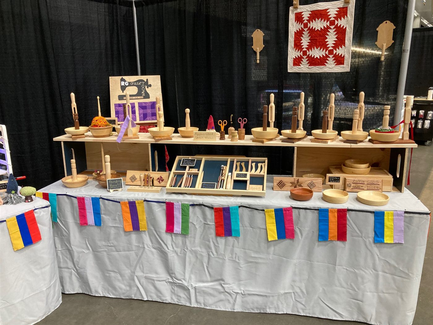 The Rippin' Good booth at a quilt show, with binding bowls along the top shelf