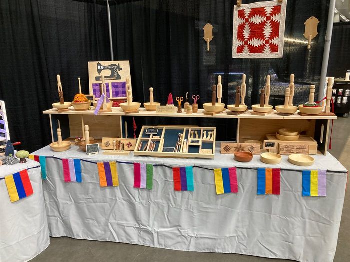 The Rippin' Good booth at a quilt show, with binding bowls along the top shelf