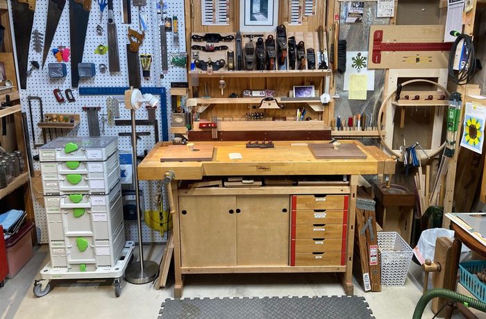The workshop bench, with saws and hand planes on the wall behind it